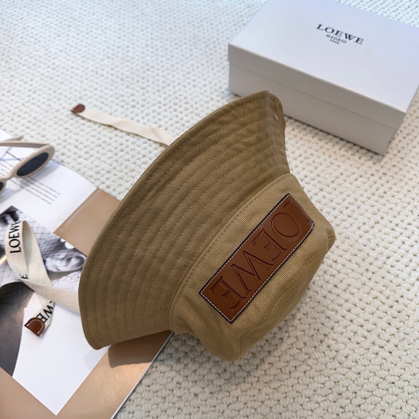 Soft canvas bucket hat with embossed leather logo patch and adjustable chin strap